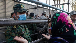 نیروی انتظامی با زنانی که بیرون درهای بسته استادیوم مشهد.jpg